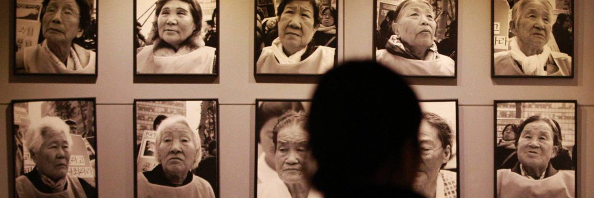Woman looking at portraits of “Comfort Women.”